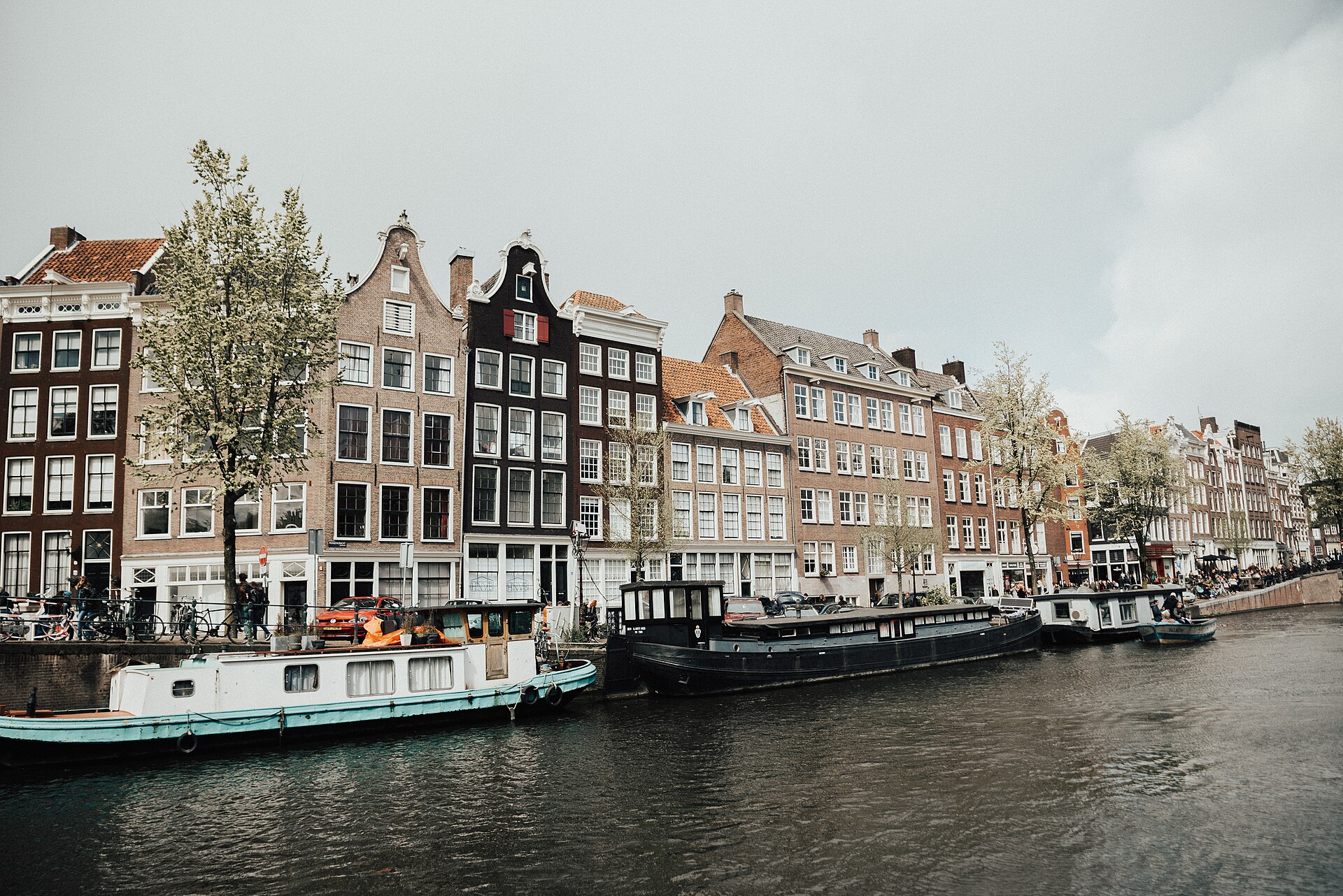 Façades typiques de maisons de canal à Amsterdam, avec bateaux amarrés.