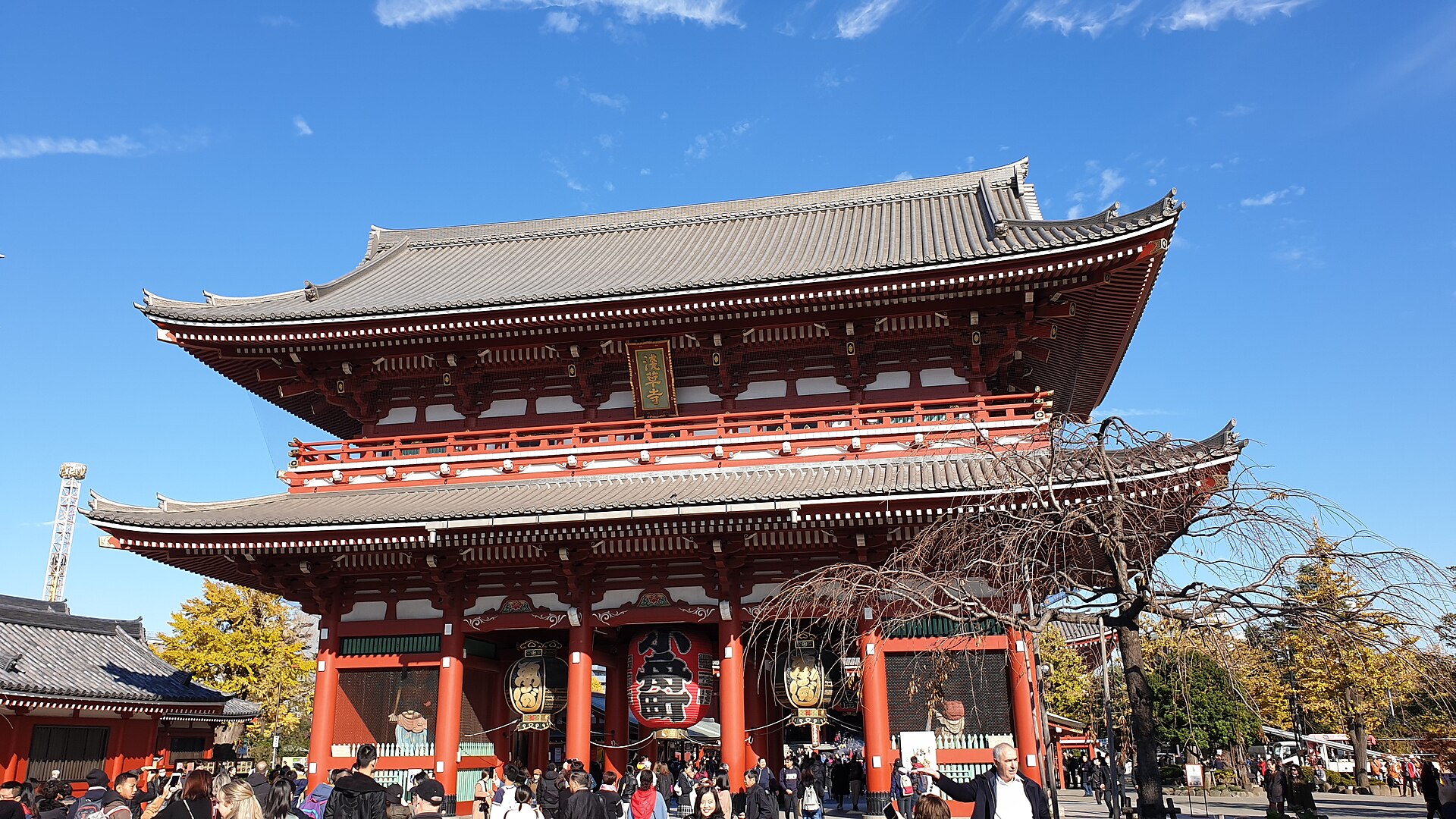 Porte Hōzōmon à deux niveaux du temple Senso-ji à Asakusa, sous un ciel bleu, avec des visiteurs.