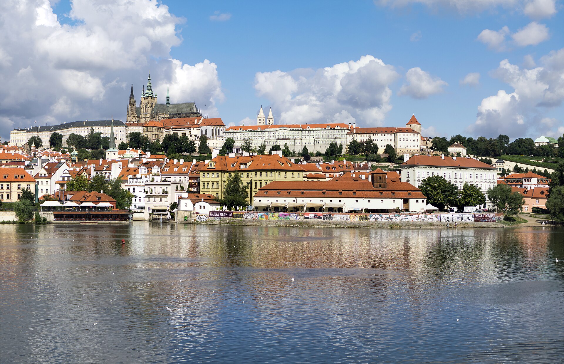 Château de Prague et toits rouges de la vieille ville vus depuis les rives de la Vltava.