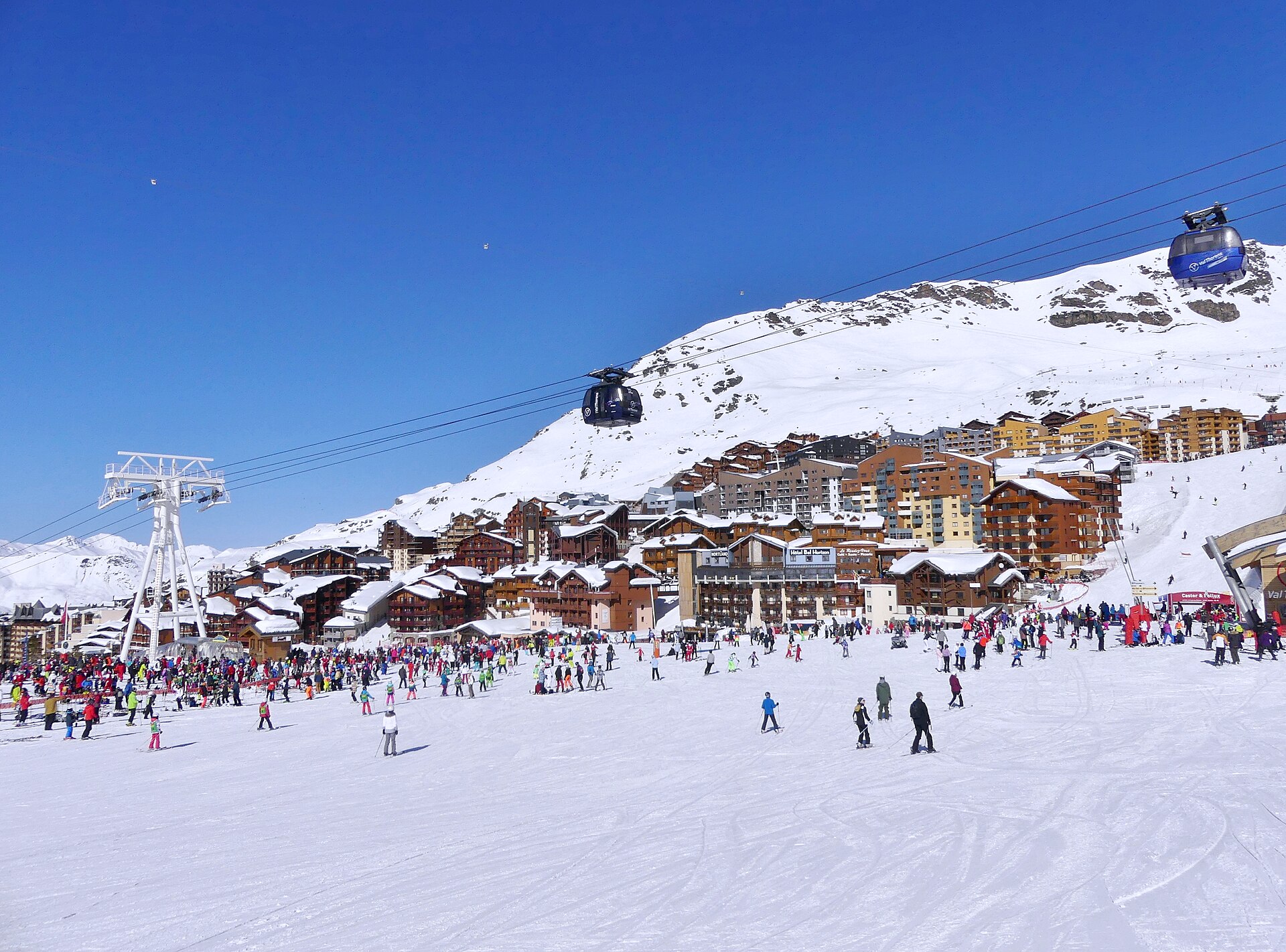Skieurs sur les pistes au pied de la station de Val Thorens, dans les Alpes françaises, avec télécabine.